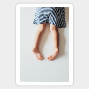 Legs of Small Girl Lying on White Tabletop Sticker